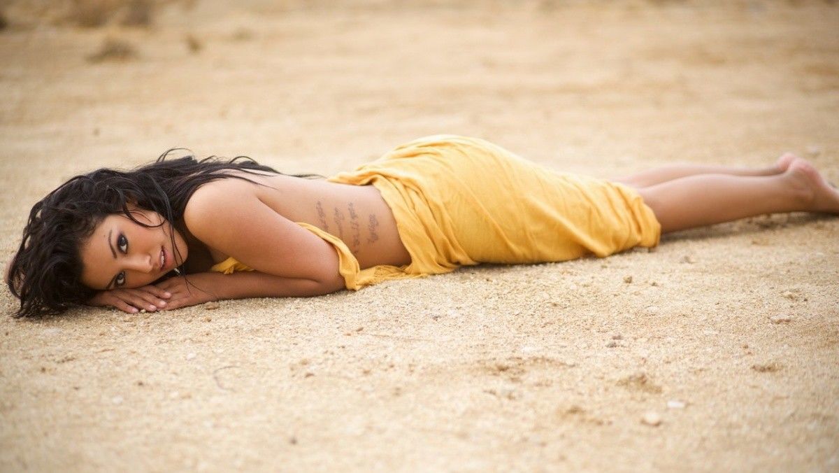 Женщина лежит на песке